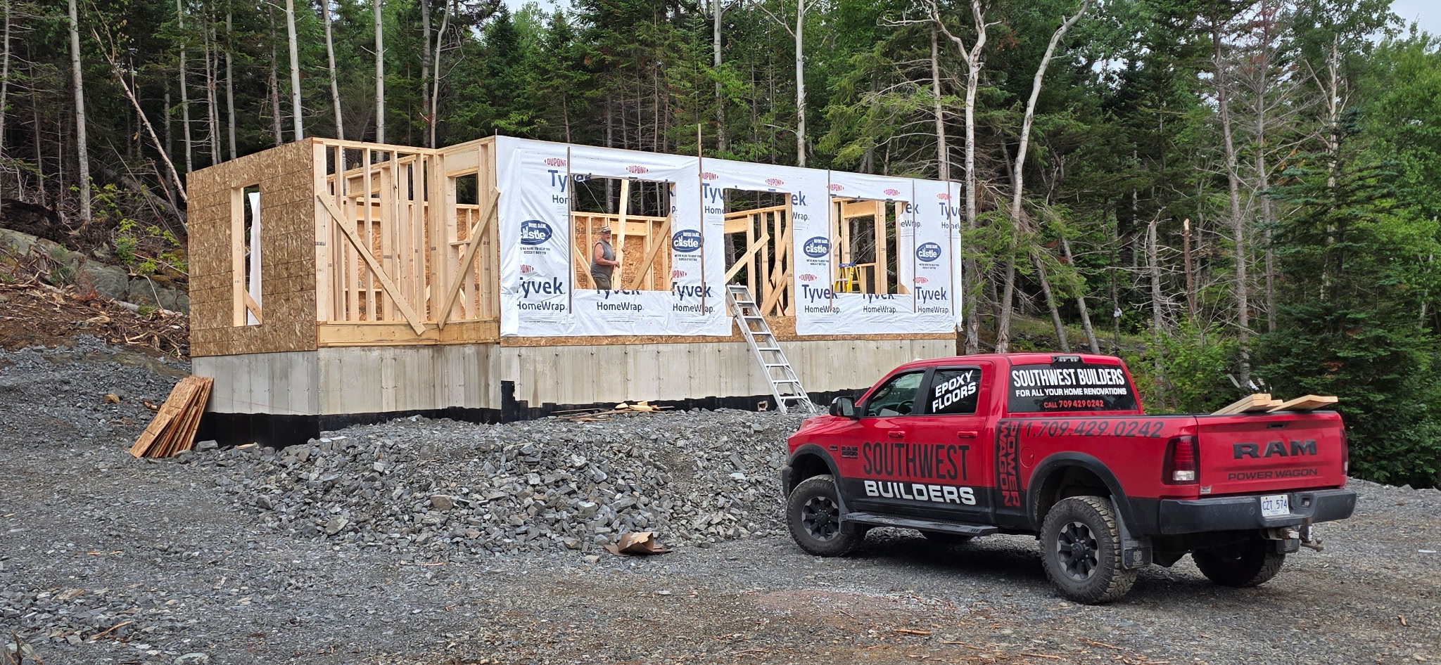 Southwest Builders framing a new structure beside the company truck